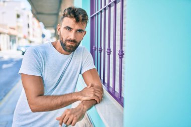 Şehrin duvarına yaslanmış, ciddi bir suratı olan genç bir İspanyol.