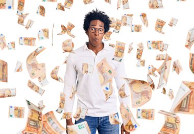 Afro saçlı, sıradan kıyafetler giyen ve gözlüklü, dudağıyla balık suratı yapan yakışıklı Afro-Amerikan bir adam. Komik ifade.