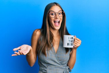 Ben patron kahve bardağından içen genç İspanyol kadın başarıyı mutlu bir gülümsemeyle ve kazanan yüz ifadesiyle kutluyorum. 