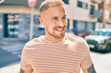 Genç İrlandalı adam gülümsüyor. Şehrin caddesinde mutlu bir şekilde yürüyor..