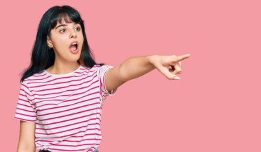 Gündelik giysiler giyen genç İspanyol kız parmağıyla işaret ederek şaşırdı, ağzı açık hayrete düştü, ön tarafta bir şey vardı. 