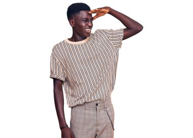 Genç, Afro-Amerikan bir adam günlük giysiler giyiyor çok mutlu ve gülümsüyor başlarını kaldırıp uzaklara bakıyor. arama kavramı. 