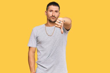 90 'ların tarzında dövmeleri olan yakışıklı bir adam mutsuz görünüyor ve reddediliyor ve olumsuz bir hareket yapıyor. kötü ifade. 