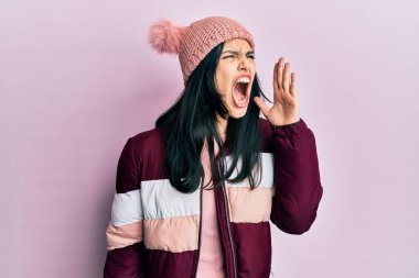 Kışlık yün kazak ve kep giyen genç İspanyol kadın el ele tutuşarak bağırıyor ve çığlık atıyordu. iletişim konsepti. 