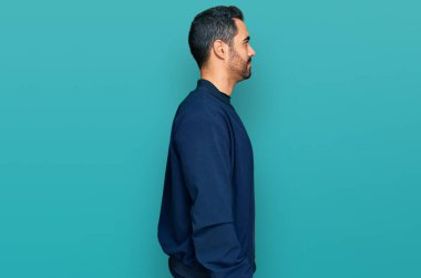 Latin kökenli genç adam rahat bir görünüm takınıyor, rahat bir görünüm takınıyor, kendine güvenen bir gülümsemeyle.. 