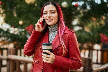 Kafkasyalı genç bir kız akıllı telefondan konuşuyor ve şehirde kahve içiyor..