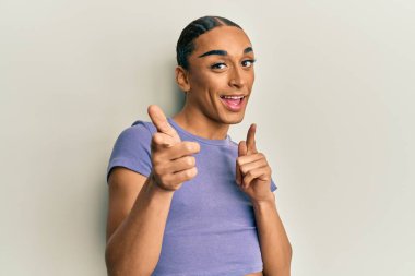 Makyaj yapan, uzun saçlı, sıradan tişörtlü, mutlu ve komik yüzlü bir İspanyol. iyi enerji ve titreşimler. 