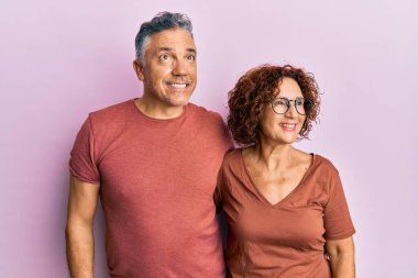 Güzel orta yaşlı çift, sıradan kıyafetler giyip gülümsüyor, yan tarafa bakıyor ve düşünüyor.. 