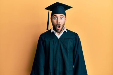 Mezuniyet şapkası ve tören cübbesi giyen genç İspanyol adam şaşırmış, korkmuş ve şaşırmış bir ifade, korku ve heyecanlı bir yüz ifadesi takınmıştı.. 