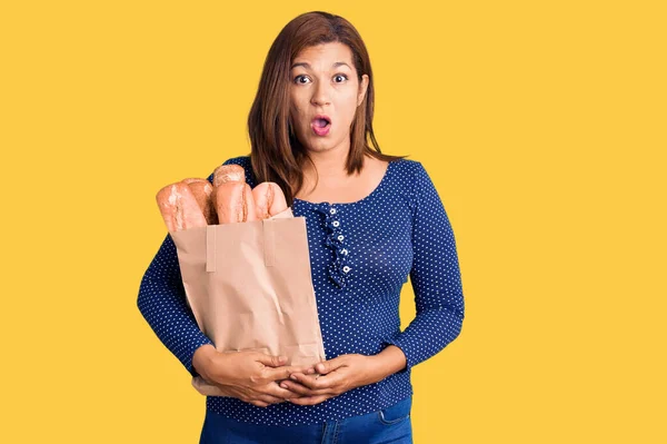 Middle Age Latin Woman Holding Paper Bag Bread Scared Amazed — ストック写真