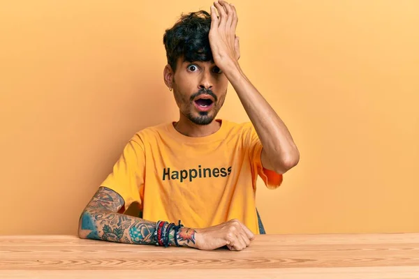 Young Hispanic Man Wearing Tshirt Happiness Word Message Sitting Table — 图库照片