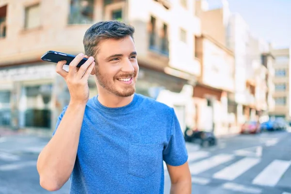 Joven Hombre Caucásico Sonriendo Feliz Escuchando Mensaje Audio Utilizando Teléfono —  Fotos de Stock