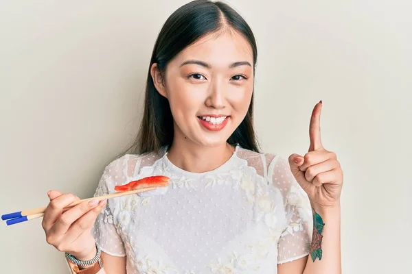 中国年轻女子吃大虾寿司时 用筷子笑着提建议或问题 满脸喜形于色 位居首位 — 图库照片