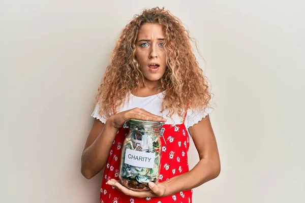 Beautiful Caucasian Teenager Girl Holding Charity Jar Money Shock Face — Foto de Stock