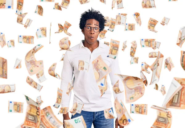 Afro saçlı, sıradan kıyafetler giyen ve gözlüklü, dudağıyla balık suratı yapan yakışıklı Afro-Amerikan bir adam. Komik ifade.