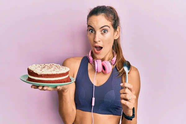 Young Beautiful Woman Wearing Gym Clothes Holding Carrot Cake Afraid — Stockfoto