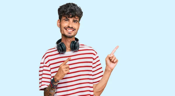 Joven Hispano Escuchando Música Usando Auriculares Sonriendo Mirando Cámara Apuntando — Foto de Stock