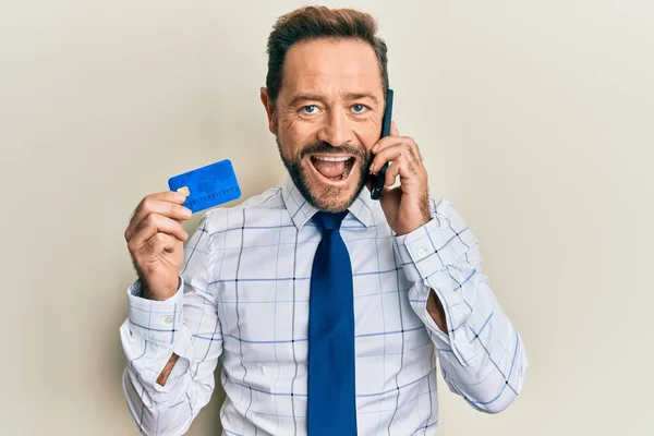 Бізнесмен Середнього Віку Говорить Смартфоні Тримаючи Кредитну Картку Посміхаючись Сміючись — стокове фото