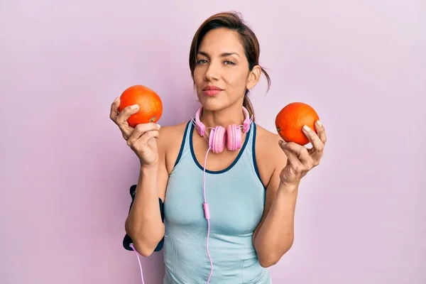 Junge Lateinamerikanische Frau Turnbekleidung Mit Kopfhörern Und Orangen Entspannt Mit — Stockfoto