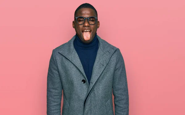 年轻的非洲裔美国人穿着商务服装 戴着眼镜 带着滑稽的表情伸出舌头 高兴极了 情感概念 — 图库照片