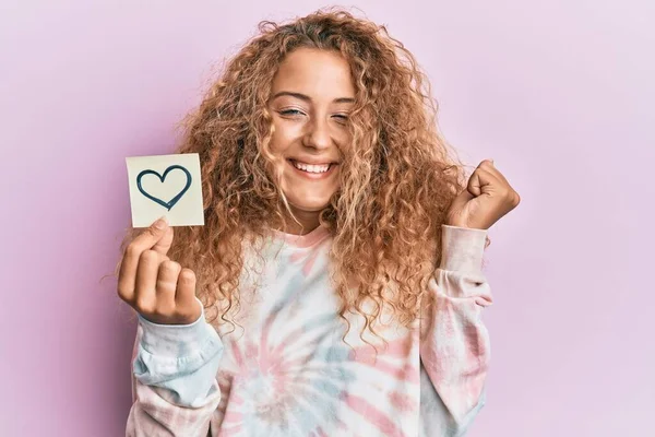 Beautiful Caucasian Teenager Girl Holding Heart Reminder Screaming Proud Celebrating — Foto de Stock