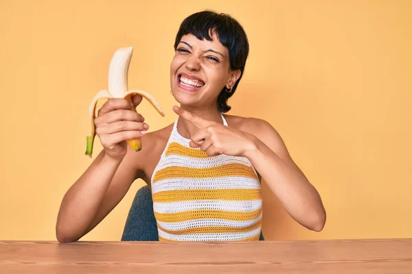 Morena Adolescente Comiendo Plátano Como Bocadillo Saludable Sonriendo Feliz Señalando — Foto de Stock