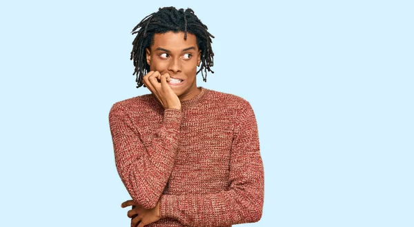 カジュアルな冬のセーターを着ている若いアフリカ系アメリカ人の男性は 口の爪をかむ上で手で強調し 緊張している 不安の問題 — ストック写真