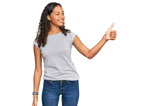 穿着休闲装的年轻的非洲裔美国女孩看上去很自豪 微笑着向旁边竖起大拇指 — 图库照片