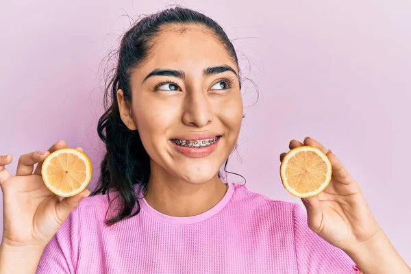 ヒスパニック系ティーン女の子とともに歯のブレースを保持レモン笑顔を見て側にと離れて考え方 — ストック写真