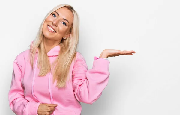 Ung Blond Kvinna Bär Casual Sweatshirt Leende Glad Presentera Och — Stockfoto