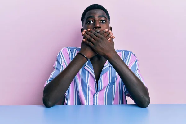 Молодий Афроамериканець Повсякденному Одязі Сидить Столі Шокований Тим Прикриває Рот — стокове фото