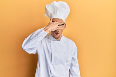 Sakallı, profesyonel aşçı üniforması giyen kel bir adam. Şoka giriyor, yüzünü ve gözlerini eliyle kapatıyor. Utanmış bir ifadeyle parmaklarından bakıyor.. 