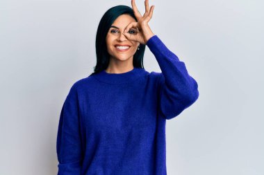 Kafkasyalı genç bir kadın günlük kıyafetler giyiyor. El hareketleriyle gülümsüyor, gözleriyle mutlu yüzüyle parmaklarının arasından bakıyor.. 