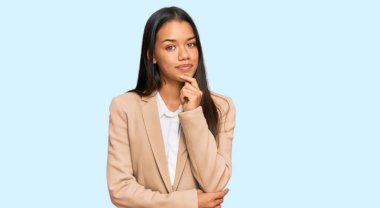 Güzel İspanyol kadın iş ceketi giyiyor kameraya kendinden emin bakıyor kollarını kavuşturup gülümseyerek ve çenesini kaldırarak. Olumlu düşünmek. 