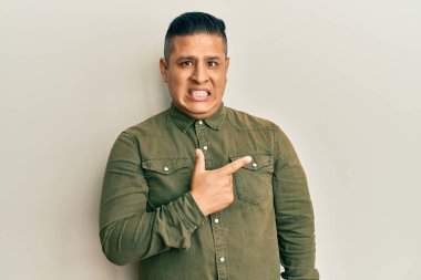 Gündelik kıyafetler giyen genç latin adam endişeli ve endişeli bir ifade takınıyor. 