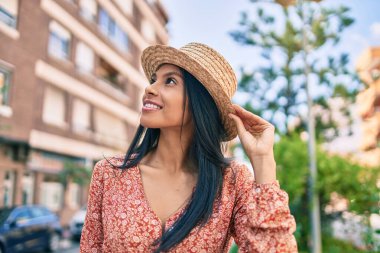 Genç Afro-Amerikan turist kadın tatilde gülümseyerek şehirde mutlu bir şekilde yürüyor..