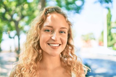 Sarışın, güzel, beyaz bir kadın. Yazın mutlu bir şekilde gülümsüyor.