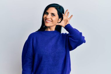 Gündelik kıyafetler giyen, el pençe divan gülümseyen, dedikoduları ve dedikoduları dinleyen genç beyaz bir kadın. Sağırlık kavramı. 