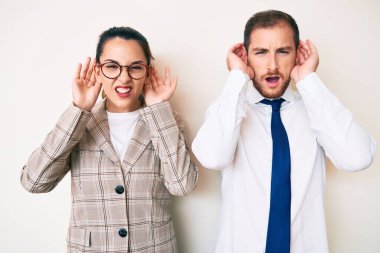 Güzel bir çift iş kıyafetleri giyip iki elini de kulak hareketi yapmaya çalışıyor. Dedikoduya meraklılar. İşitme sorunu, sağır 