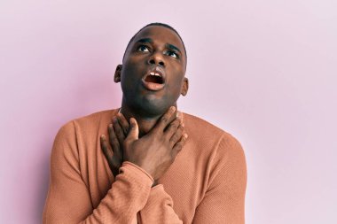 Genç, Afro-Amerikan bir adam günlük kıyafetler giyip bağırıyor ve boğularak ölüyor çünkü boğularak can yakıyor. Sağlık problemi. Boğulma ve intihar konsepti. 