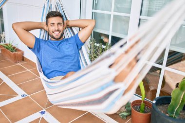 Genç İspanyol adam rahatlamış gülümsüyor mutlu bir şekilde terasta yatıyordu..