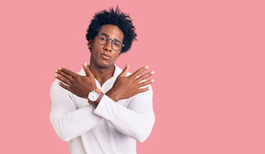 Afro saçlı, sıradan giyinmiş ve gözlüklü yakışıklı Afro-Amerikalı adam. Kollarını kavuşturup, avuç içlerine kadar reddetme ifadesi, kızgın surat ifadesi. 