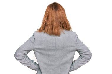 İş stili ve gözlüklü genç beyaz kadın kolları vücudunda geriye doğru bakıyor. 