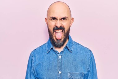 Sıradan kıyafetler giyen genç yakışıklı bir adam komik bir ifadeyle dilini dışarı çıkartıyor. duygu kavramı. 