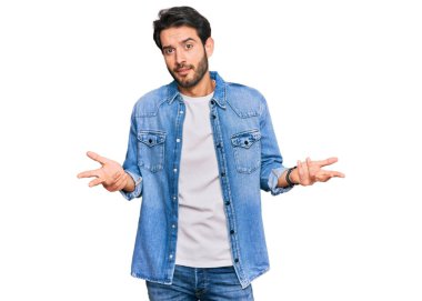 Gündelik giysiler giyen genç İspanyol adam habersiz ve kolları açık, hiçbir fikri yok.. 