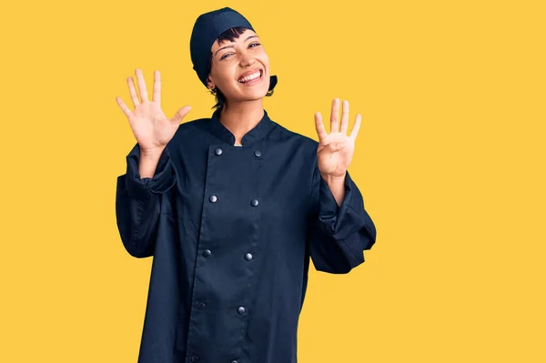 年轻的黑发女子 身穿专业厨师制服 用9号手指指尖 面带微笑 自信而快乐 — 图库照片