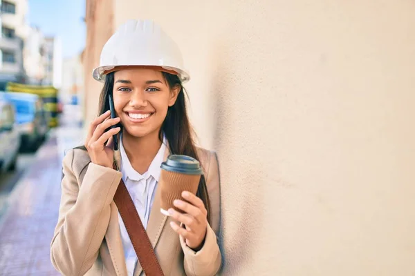 年轻的拉丁建筑师女孩在城市里用智能手机聊天喝咖啡 — 图库照片