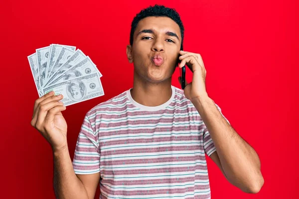 Hombre Árabe Joven Teniendo Conversación Hablando Teléfono Inteligente Sosteniendo Dólares —  Fotos de Stock