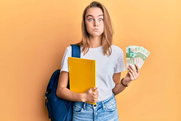 Красива Блондинка Студентському Рюкзаку Тримає Банкноти Набиваючи Щоки Смішним Обличчям — стокове фото