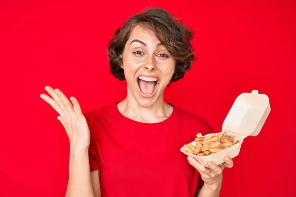 Young Hispanic Woman Holding Potato Chip Celebrating Victory Happy Smile — Stock Photo, Image